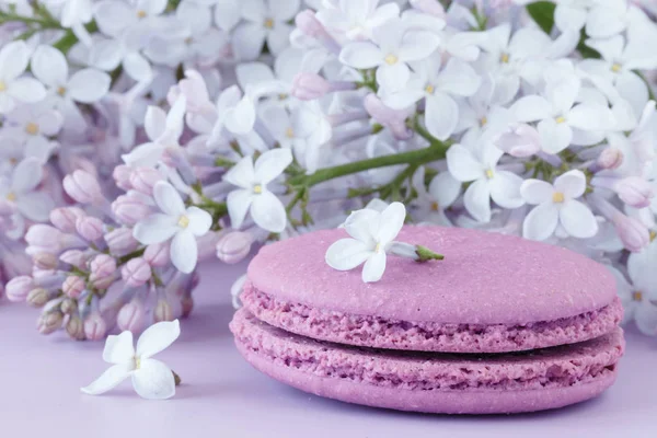 Taza de café negro, flores lila y dulce pastel macar francés —  Fotos de Stock