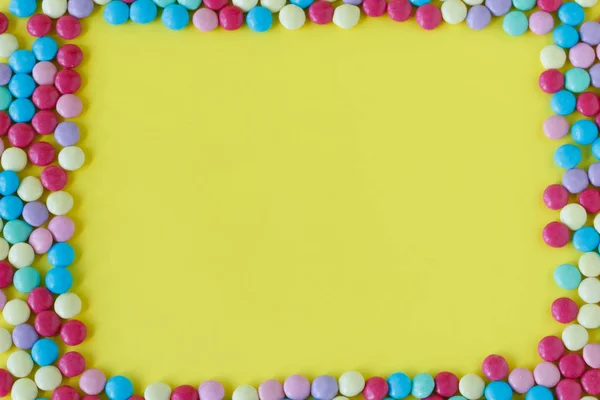 Bonbons colorés sur fond jaune — Photo