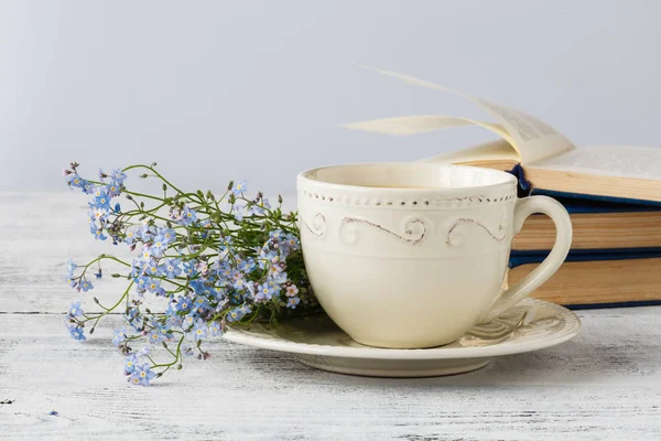 Bouquet of forget me not flowers and old books on wooden table — Stock Photo, Image