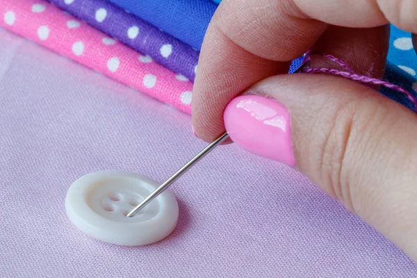 Aguja de mano coser un botón —  Fotos de Stock