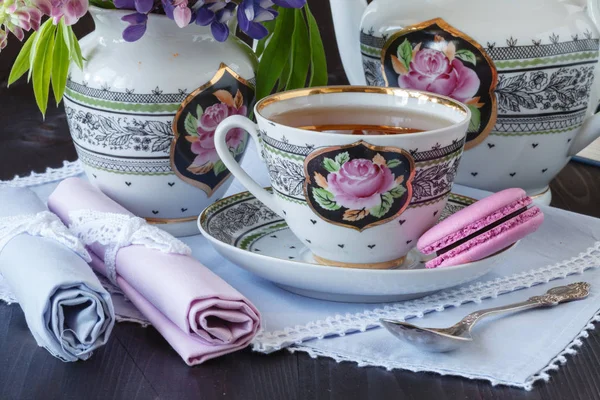 Taza de té con libros y flores sobre fondo de madera — Foto de Stock