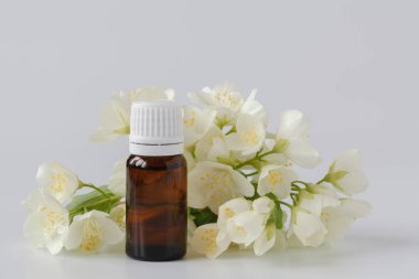 Yasemin çiçekleri ve beyaz arka planda gerekli yağ