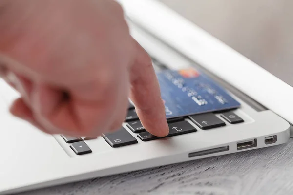 Manos sosteniendo la tarjeta de crédito y utilizando el ordenador portátil. Compras online — Foto de Stock