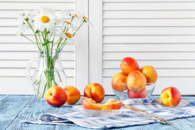 mavi ahşap masa ve daisy Vas'deki / daki kase taze olgun şeftali