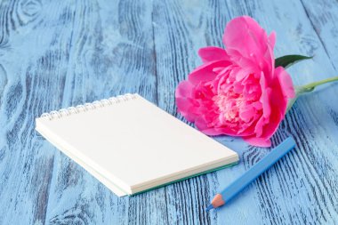 Defter bir kalem ve peonies çiçekler üzerinde ahşap backgro ile