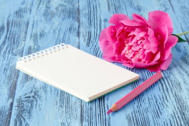 Defter bir kalem ve peonies çiçekler üzerinde ahşap backgro ile