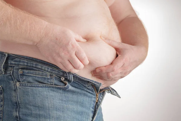 Homem tocando sua barriga gorda no fundo branco — Fotografia de Stock