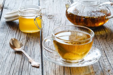 Ahşap bir siyah arka plan üzerine lezzetli bitkisel çay demlendi