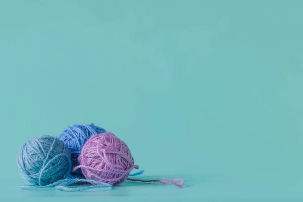 Woolen yarn in balls on a aquamarine background — Stock Photo, Image