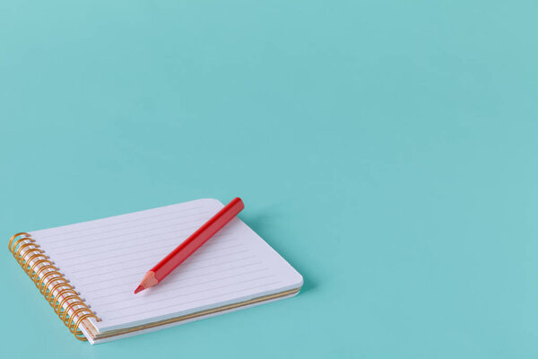 Открыть спиральный чистый блокнот с карандашом на синем бумажном фоне
