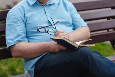 yakışıklı genç işadamı rahat kıyafetler ve bir kitap okuma gözlük
