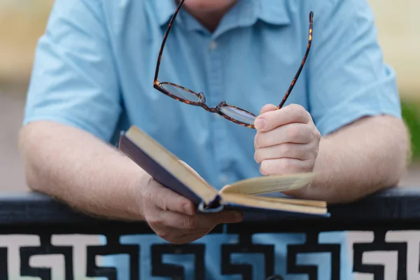 Jovem abrindo e lendo um livro, close-up. — Fotografia de Stock