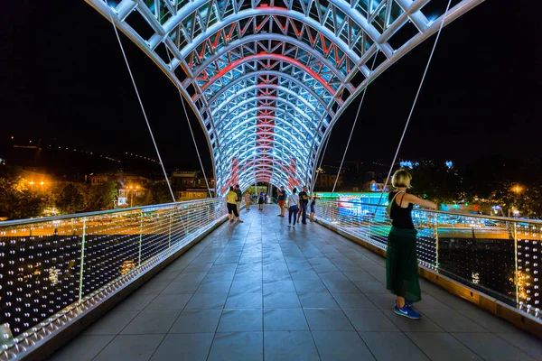 Vista nocturna del "Puente de la Paz" en Tiflis. Georgia País — Foto de Stock