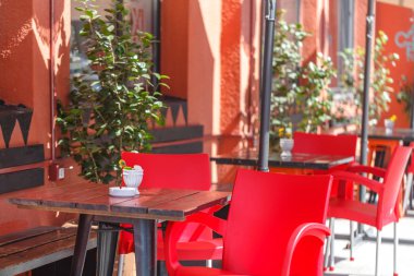 Kırmızı masa ve sandalyeler ile açık Restoran