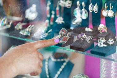 Vitrin ya da alışveriş penceresine arayan kadın. Alışveriş kadın mücevher dükkanında seçer.