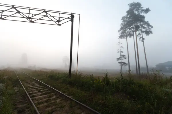 Ferrovia sombria no nevoeiro — Fotografia de Stock