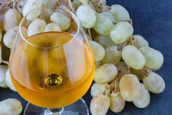 White wine in a glass with fall grapes