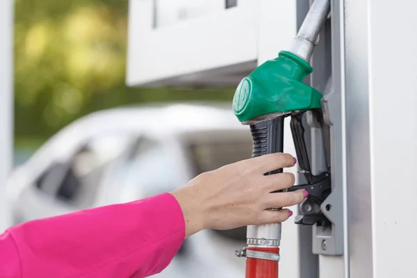 stock image Woman holding a fuel nozzle on the gasoline station