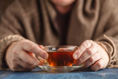 Erkek elinde cam fincan sıcak çay