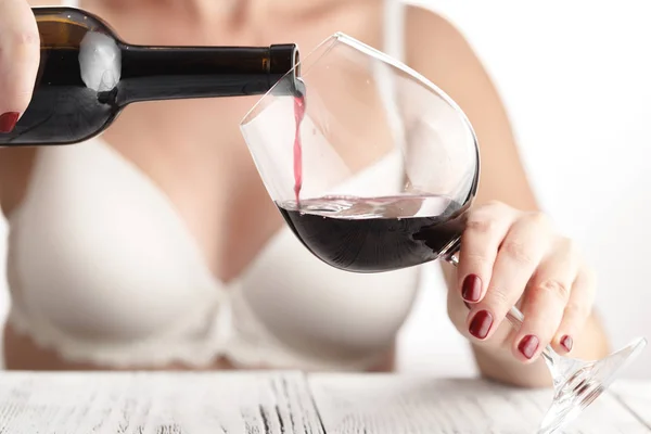 Mujer en blanco lingery verter vino tinto en vaso —  Fotos de Stock