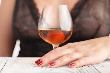 Sexy beautiful woman holding glass of whisky bourbon clipart