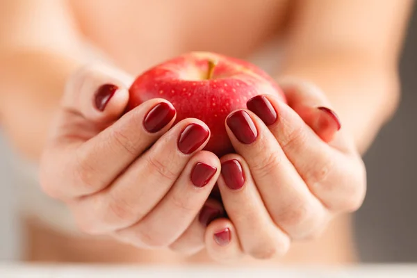 Atractiva hembra sosteniendo alimentos de frutas manzana en manos cuidadas — Foto de Stock