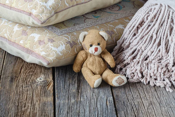 Cute toy bear and plaid on table