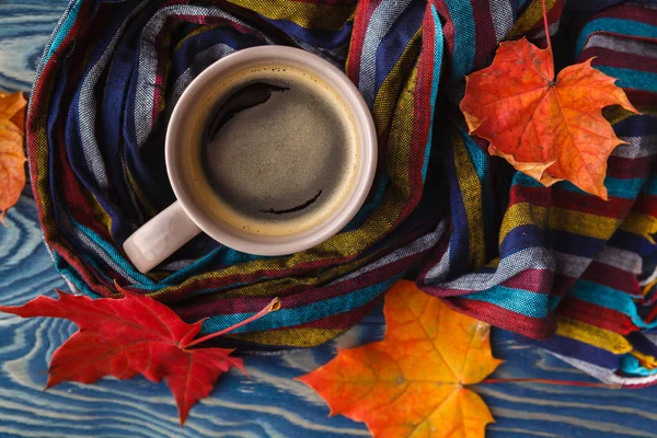 Tasse Kaffee, Herbstblätter und ein warmer Schal auf schwarzem Holztisch — Stockfoto