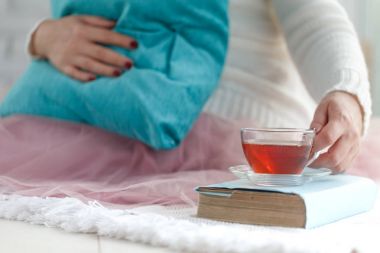 Yatakta kitap okurken oturan kadın