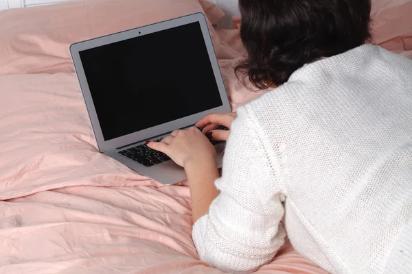 Woman with laptop notebook on bed in bedroom home surfing internet — Stock Photo, Image