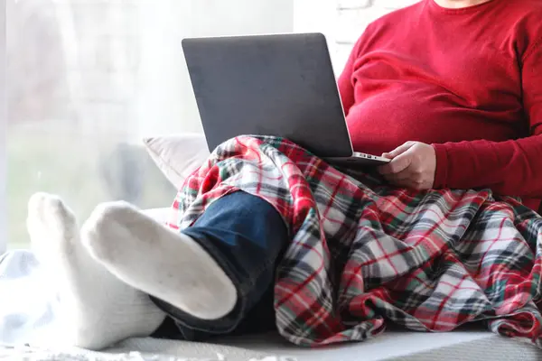 Dizüstü evde oturma odasında kullanarak katta oturan genç adam