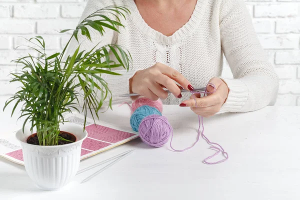 As mãos das mulheres são tricotadas. Processo de tricô. Belo delicado tricô de madeira com agulhas de tricô . — Fotografia de Stock