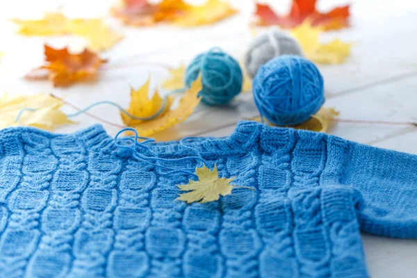 木製の背景に生まれたばかりの赤ちゃんのニットの青いセーター — ストック写真