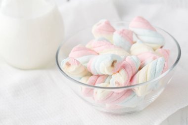 Beyaz ve pembe bükülmüş krema ve süt beyaz ahşap bir masa üzerinde bir sürahi. Güzel açık renkli. 