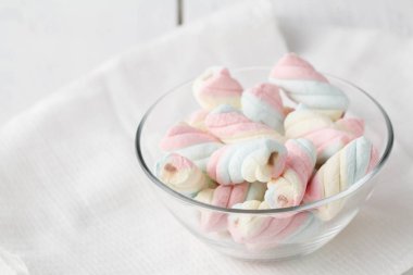 Ahşap arka plan üzerine bir fincan bükülmüş marshmallow.