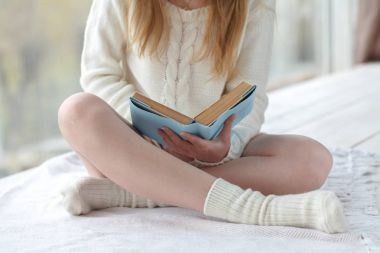 Mutlu esmer evde oturma odasında bir kitap okuma