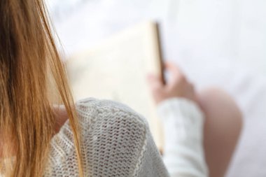 Evde en sevdiği kitap okuma. Sıcak güzel genç kadın