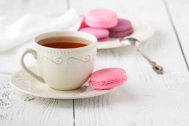 Ahşap masa üzerinde sıcak çay ile macaroons.