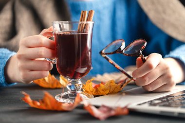 Kadın oturup evde sıcak bir içecek ile Sonbahar sezonu