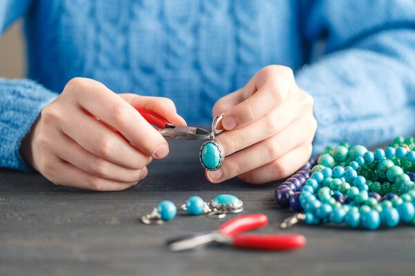 Лицо, делающее украшения с помощью проволоки, цепей и бусин и других материалов с помощью ремесленных инструментов
