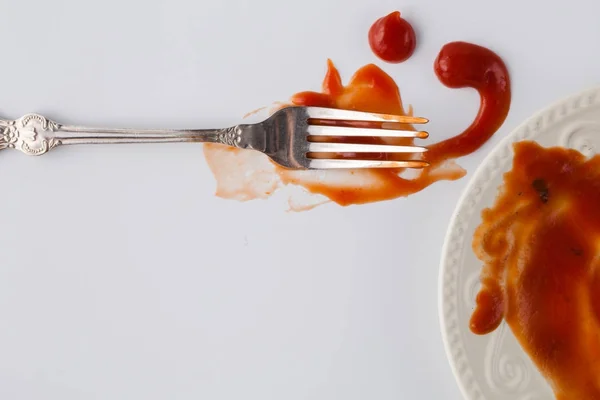 Fork ketshup tomate manchado na mesa com prato — Fotografia de Stock