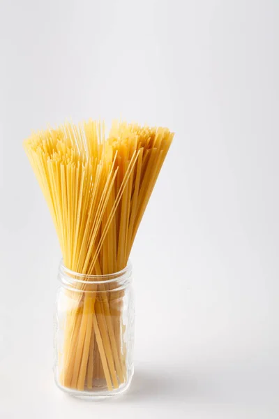 Spaghetti, powiązany z sznurka, stać pionowo na białym tle na liczby biały — Zdjęcie stockowe