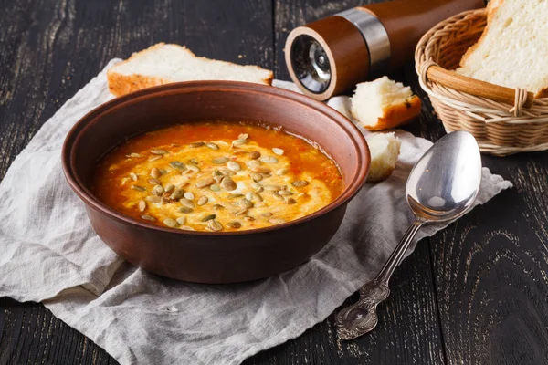 Sopa de calabaza caliente vegetariana que sirve en un tazón sobre una mesa rústica — Foto de Stock