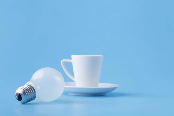 能量为长的天, 咖啡杯子在蓝色与电灯泡 — 图库照片