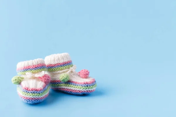 Newborn announcement Baby booties on blue with copy space — Stock Photo, Image