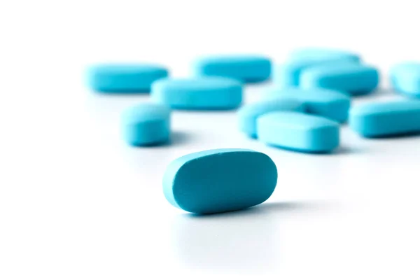 Kupie niebieskie tabletki na białym tle — Zdjęcie stockowe