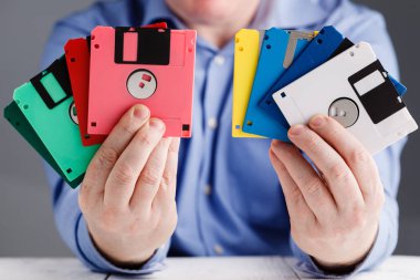 Male hold floppy disk in hands, retro storage clipart