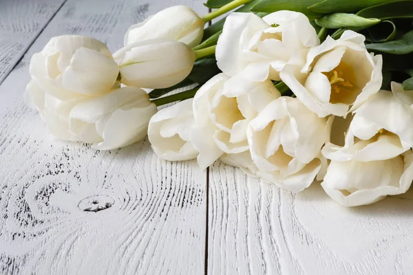 Muchos tulipanes blancos sobre fondo de madera — Foto de Stock