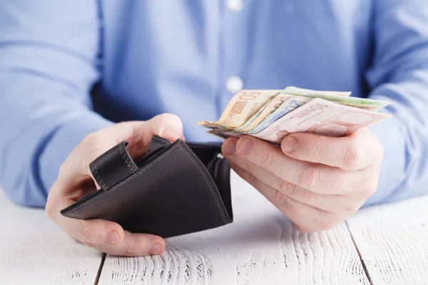 Las manos sacando dinero de la billetera — Foto de Stock