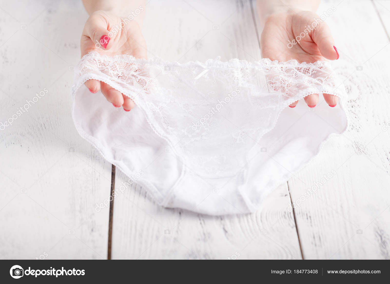 Sexy transparent panties on white background in female hands Stock